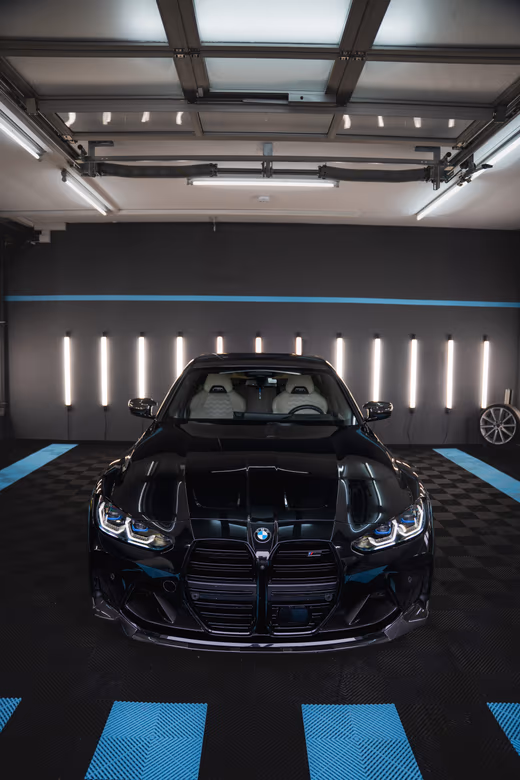 Schwarzer BMW M4 Frontansicht im LED-Studio nach Lackaufbereitung